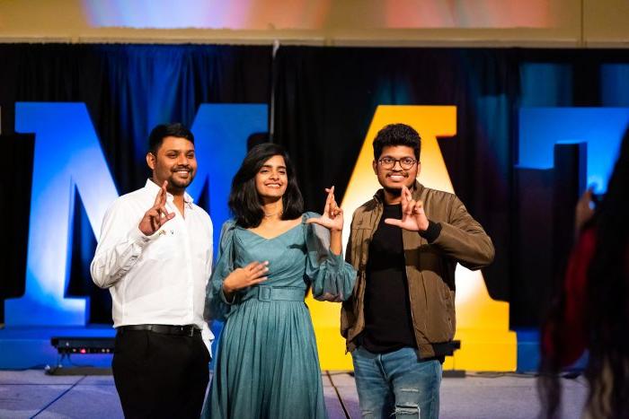 three students signing the leo sign.