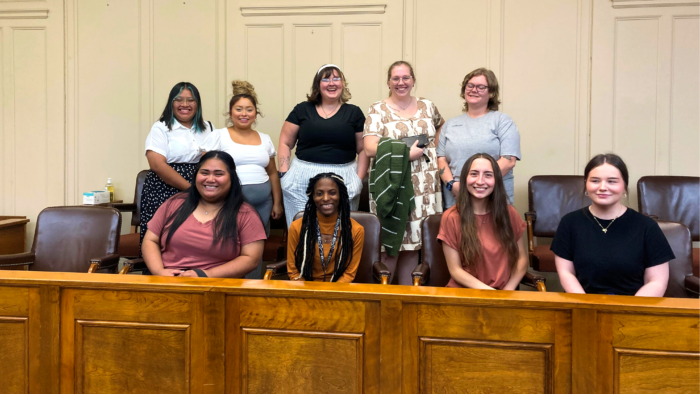 Nine A&M-Commerce students sit in two rows within the jury box of a courtroom.