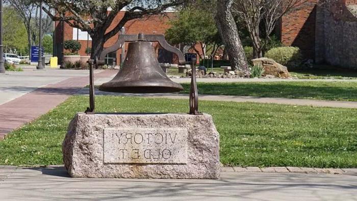 Metal bell is set on a stone base with the words "Victory Old E.T." etched in the stone.