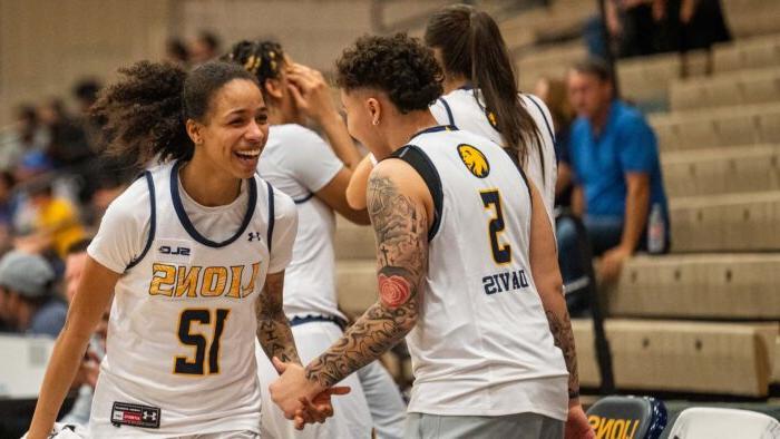 Two basketball players smile at each other and celebrate success.