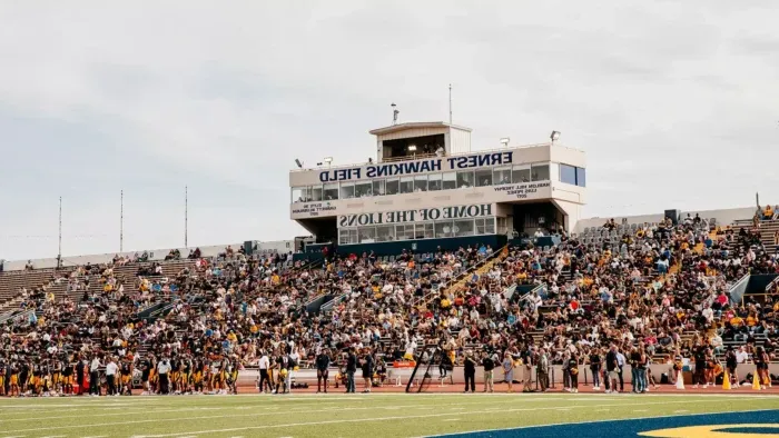 Football stadium bleachers are filled with fans.